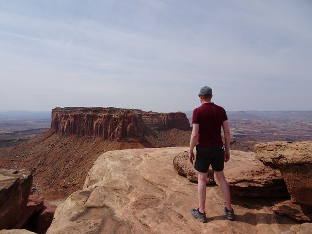 Me wearing the hiking boots, seen from behind with Canyonlands National Park in the background.
