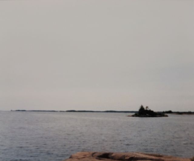 'A shot of the horizon, with a lake in the foreground and a small island.'